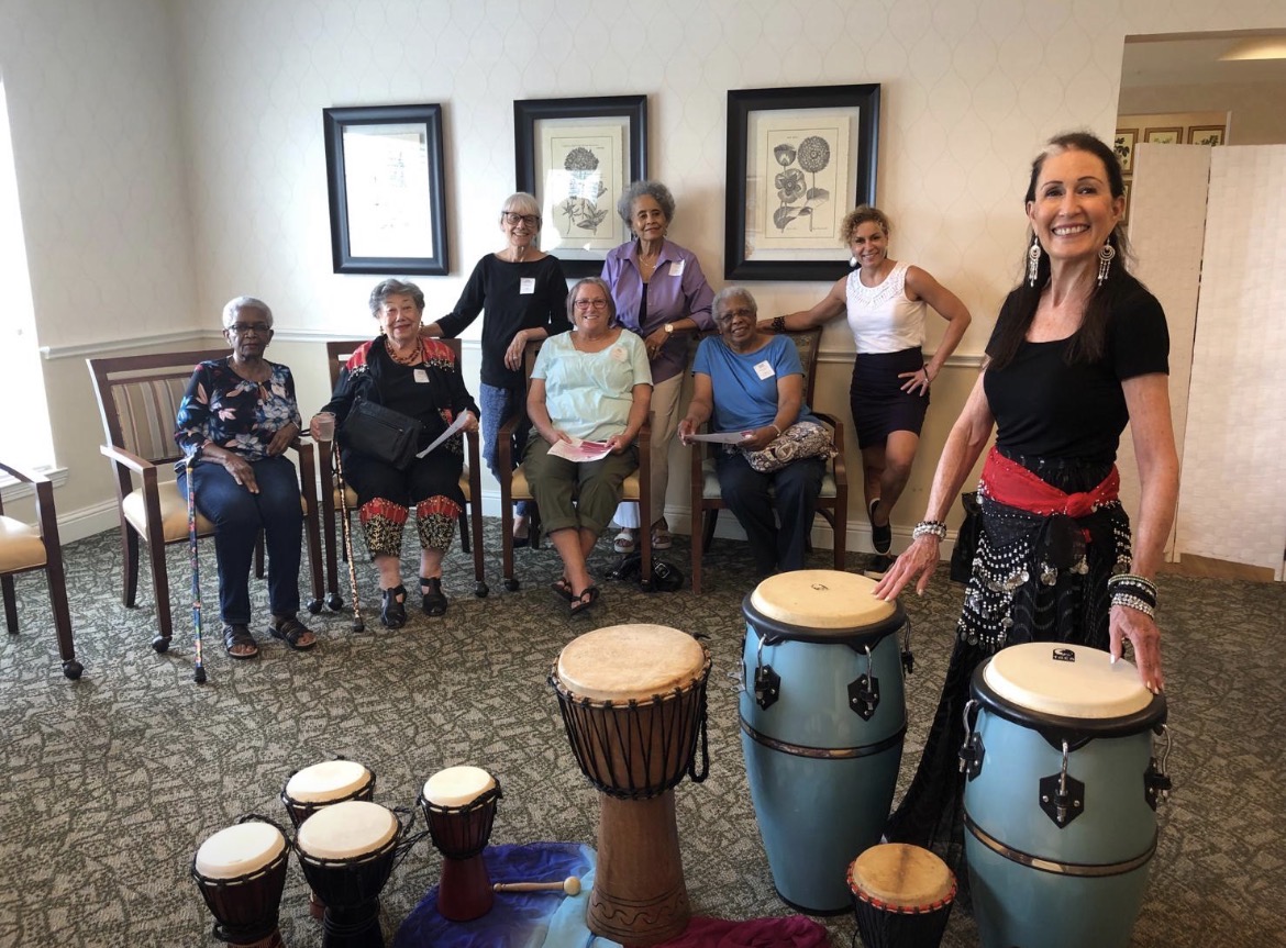 Residents enjoying a drumming activity at a senior community